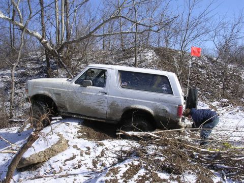 1995 Jeep Cherokee - A white Ford Bronco navigates a snowy and muddy off-road course.