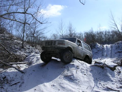 1995 Jeep Cherokee - Ford Bronco navigates a challenging snowy terrain during an off-road excursion.
