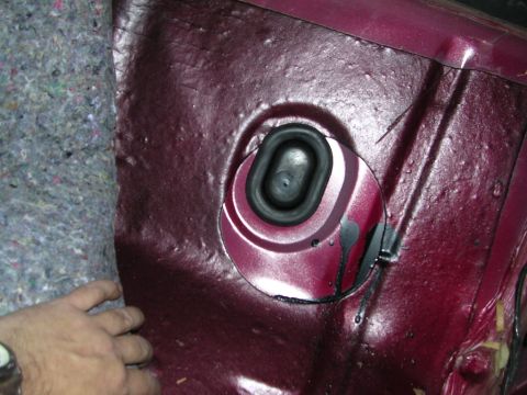 1995 Ford Bronco - Close-up view of an interior panel with a rubber grommet and sound deadening material visible.