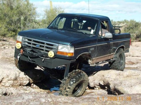 1994 Ford Bronco - This modified Ford Bronco is shown off-roading over rocks and through mud.
