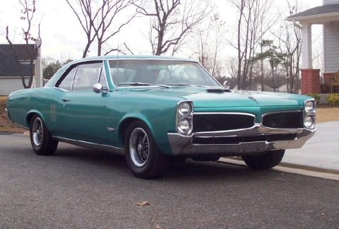 1967 Pontiac Lemans - Teal green 1967 Pontiac Lemans coupe with a hood scoop and chrome trim.