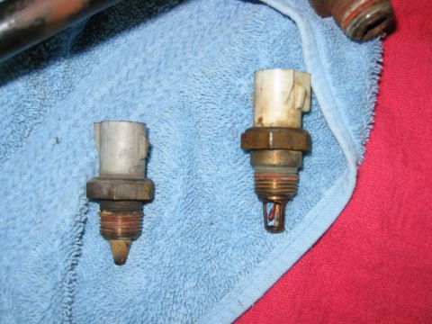 1992 Ford Bronco - Two automotive temperature sensors are shown, one with a pointed tip and the other with a visible probe, resting on a blue towel.