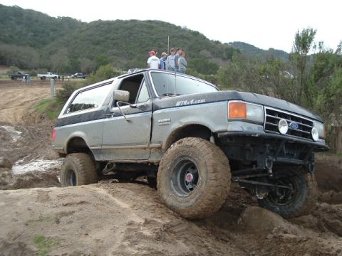 1989 Ford Bronco - Off-road enthusiasts tackle a challenging mud course in a 1989 Ford Bronco.