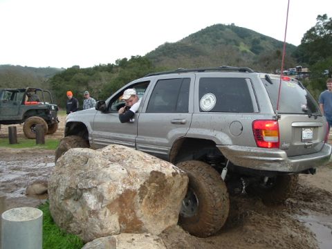 1989 Ford Bronco - A silver Jeep Grand Cherokee tackles a challenging off-road course, with another Jeep visible in the background.