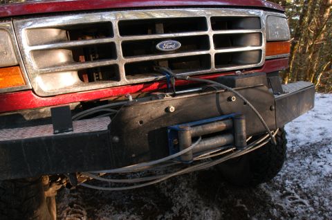 1995 Ford Bronco - Front view of a red 1995 Ford Bronco, equipped with a winch mounted on the aftermarket bumper.