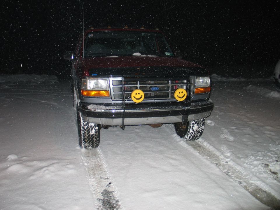 1995 Ford Bronco front view with smiley face lights in snow