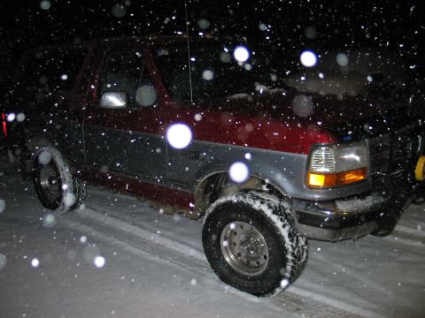 1995 Ford Bronco - Ford Bronco driving through snow at night.
