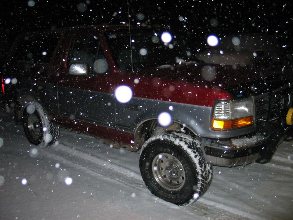 1995 Ford Bronco driving in snow at night