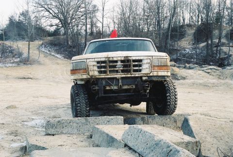 1995 Ford Bronco - A white 1995 Ford Bronco navigates an obstacle course, positioned on concrete blocks.