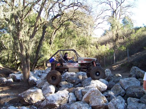 1998 Ford Ranger - A custom off-road buggy with a roll cage navigates a rocky trail, demonstrating its off-road capabilities.