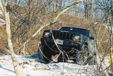 1995 Ford Bronco - Jeep Cherokee XJ navigates a snowy, rocky trail during an off-road excursion.