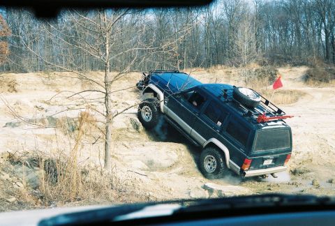 1995 Ford Bronco - A Jeep Cherokee XJ navigates a steep, sandy incline during an off-road excursion.