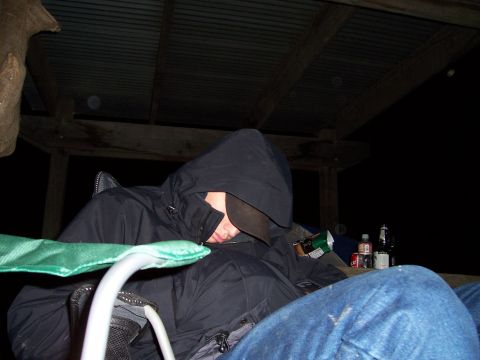 1998 Ford Ranger - A person sleeps under a covered structure at night, with drinks nearby.