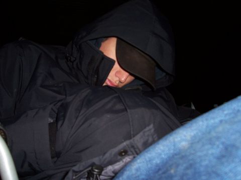 1998 Ford Ranger - A person sleeps in the interior of a vehicle, partially obscured by a hood and baseball cap.