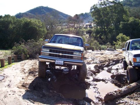 1998 Ford Ranger - Two lifted pickup trucks tackle a challenging muddy off-road course.