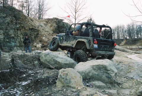 1995 Ford Bronco - A black Jeep Wrangler TJ tackles a rocky obstacle course during an off-road adventure.