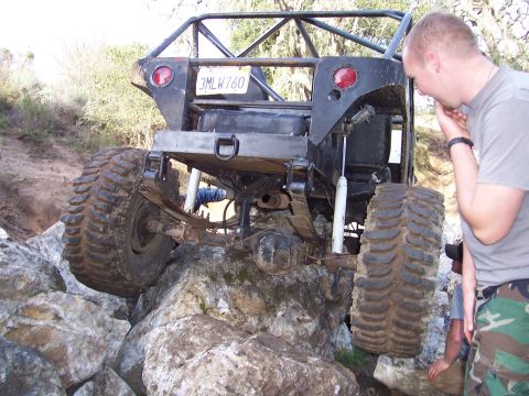 1998 Ford Ranger - Custom off-road vehicle is attempting to climb over large rocks on a trail.