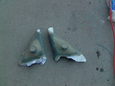 1999 Ford Taurus - Two triangular car mirror housings are shown on a concrete surface.