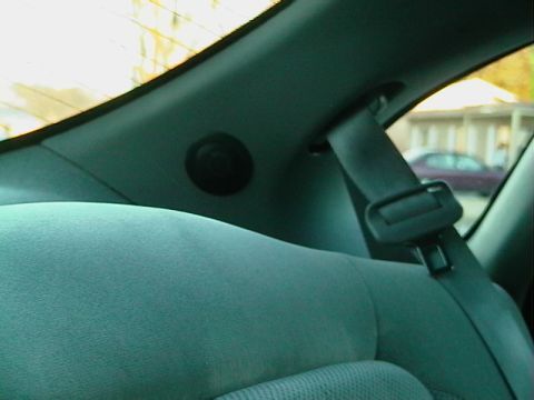 1999 Ford Taurus - Rear interior view showing the seatbelt and a glimpse of another vehicle outside.
