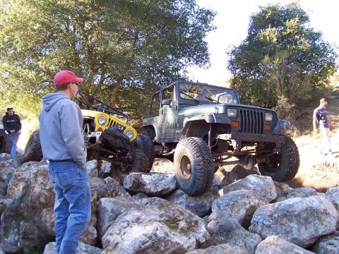 1998 Ford Ranger - Two modified Jeeps navigating a rocky trail with onlookers.