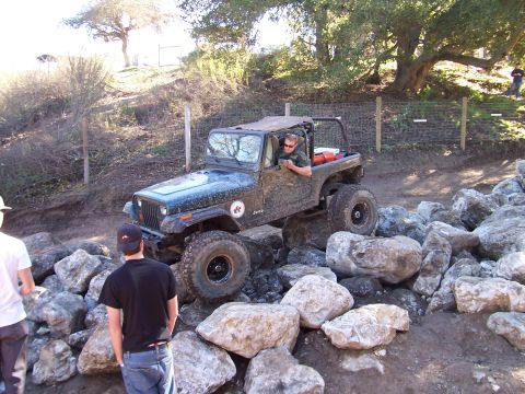 1998 Ford Ranger - A Jeep Wrangler TJ is shown off-roading over a rocky terrain.