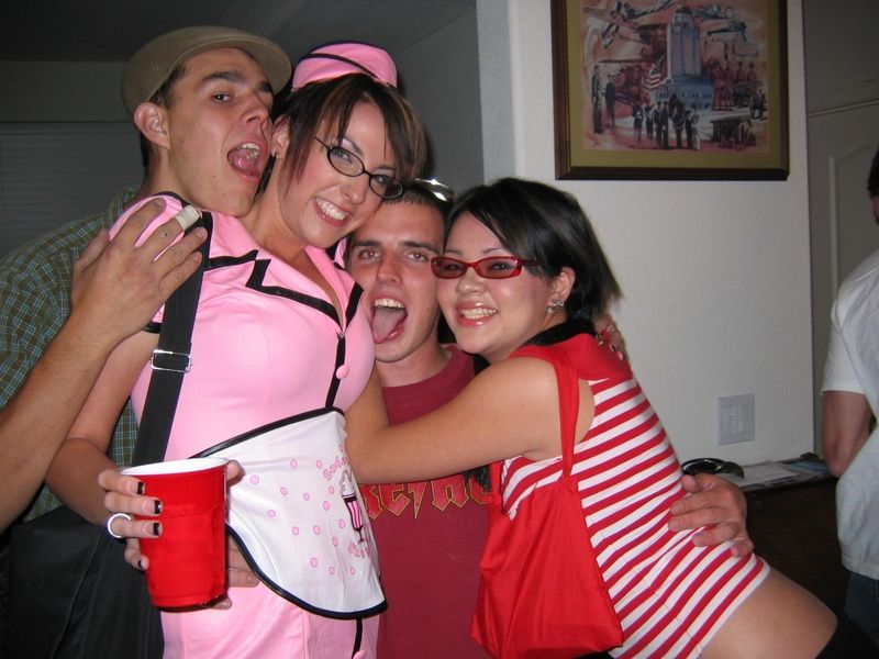 Four people in costumes, one in a pink diner uniform holding a red cup