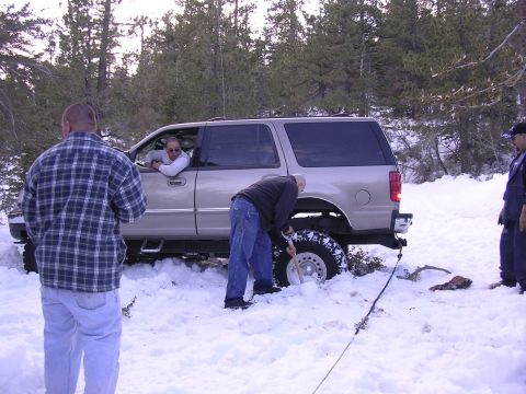 1999 Toyota Tacoma - People digging an SUV out of deep snow in a wooded area.