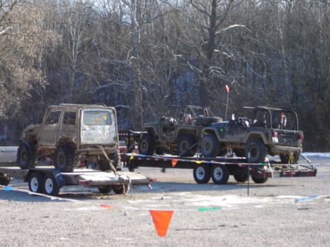 1992 Ford Bronco - Multiple off-road vehicles are transported on trailers in an outdoor setting.