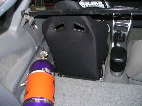 1994 Ford Probe - The interior of a car shows a racing seat and a nitrous oxide tank, suggesting performance modifications.