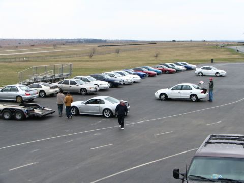 1994 Ford Probe - Several cars are parked on a track, including a silver Ford Mustang coupe and a trailer.