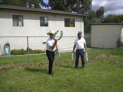 1979 Ford Bronco - Two men are playing horseshoes in a grassy yard in front of a house.