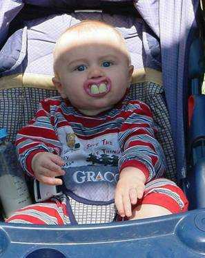 1979 Ford Bronco - A baby wearing a bib and a striped shirt sits in a stroller, with a "Super Motors" logo visible at the bottom.