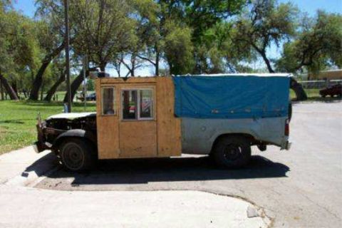 1979 Ford Bronco - This heavily modified pickup truck features a custom wooden cabin and a blue tarp over the bed.