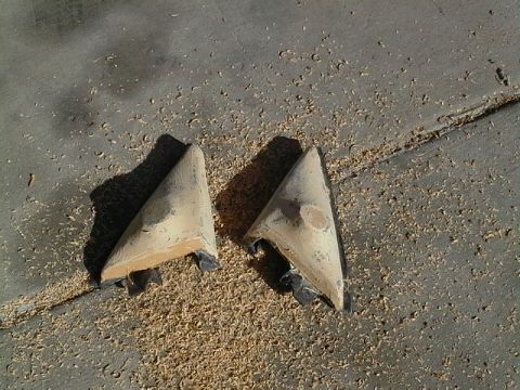 1999 Ford Taurus - Two car mirror housings sit on a concrete surface covered in wood shavings.