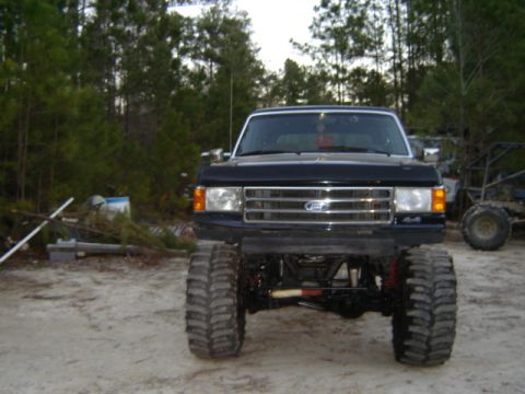 1989 Ford Bronco - This lifted 1989 Ford Bronco features oversized tires and a prominent front grille with the Ford badge.