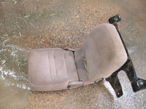 1994 Ford Bronco - A single car seat is shown on a wet, gravelly surface, with visible text from a website watermark.
