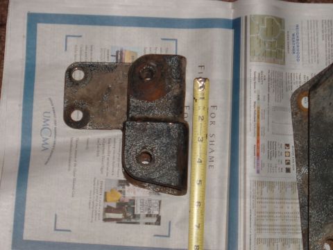 1994 Ford Bronco - A metal bracket is shown next to a tape measure, indicating its size.