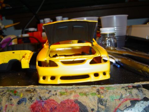 1979 Ford Bronco - A yellow model car is shown with its hood open, in a state of assembly.