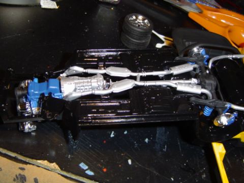 1979 Ford Bronco - A detailed model of a vehicle's chassis, engine, and exhaust system is shown, along with a separate tire.