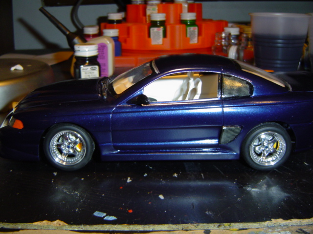 Dark blue model car with chrome wheels on a workbench