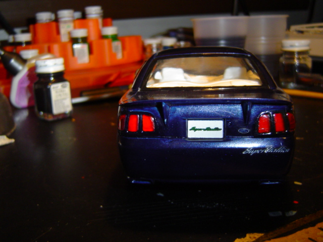 Model car's rear end, blue with red taillights and a white plate that says 'Super Stallion'