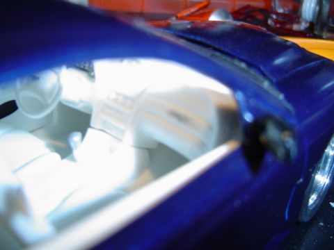 1979 Ford Bronco - Close-up of a blue toy car's interior, showing white seats and dashboard details.