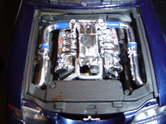 Model engine bay with chrome V8 engine and blue hoses