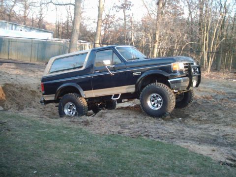 1989 Ford Bronco - This Ford Bronco is navigating a challenging dirt incline, its off-road capabilities.