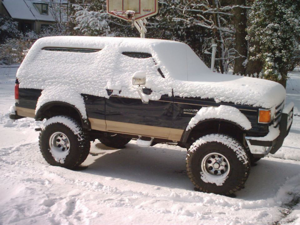 1989 Ford Bronco in snow, 3q-front view. Dark blue with tan trim
