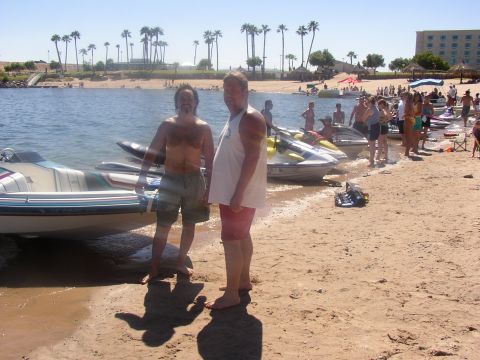 1990 Ford Bronco - People enjoy a sunny day at the beach with jet skis lined up by the water.
