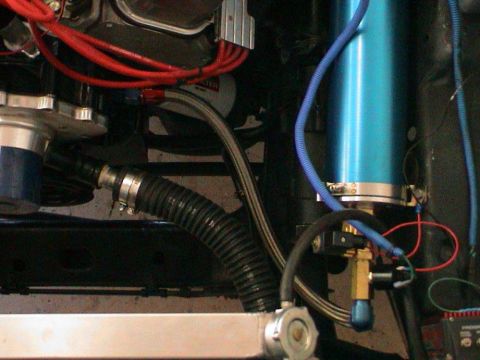 1979 Ford Bronco - Close-up of engine bay components including a blue canister and various hoses and wires.