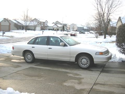 1997 Ford Crown Victoria - A white 1997 Ford Crown Victoria is parked in a suburban driveway during winter.