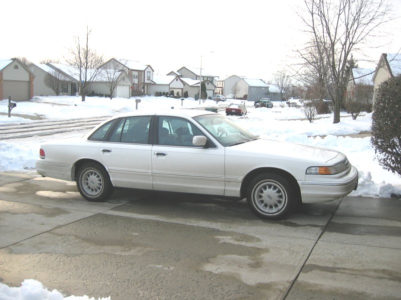White 1997 Ford Crown Victoria parked in a snowy driveway