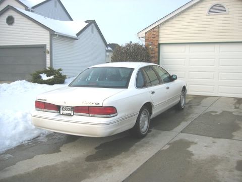 1997 Ford Crown Victoria - Rear view of a white 1997 Ford Crown Victoria parked in a suburban driveway during winter.